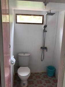 a small bathroom with a toilet and a window at Villa Beach Mentawai in Katiet