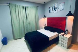 a bedroom with a large bed with a red headboard at Apartamento confortable y cálido in Itagüí