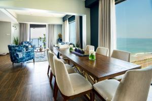 uma sala de jantar com mesa e cadeiras e o oceano em MaRadha Colombo em Colombo