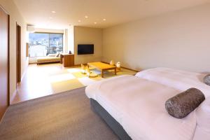 諏訪市にあるホテルすわ湖苑のベッド2台とテレビが備わるホテルルームです。