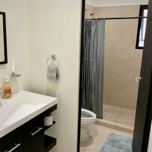 een badkamer met een douche, een wastafel en een toilet bij YellowSub apartments in Cancun