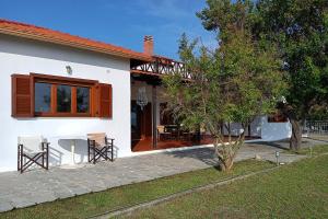 una casa bianca con tavolo e sedie in cortile di Villa Totti a Ierissós