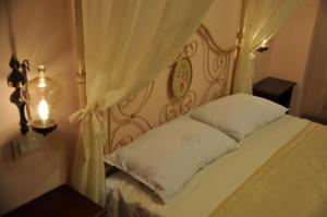 a bedroom with a canopy bed with white pillows at La Casa del Falegname in Umbertide +35 photos