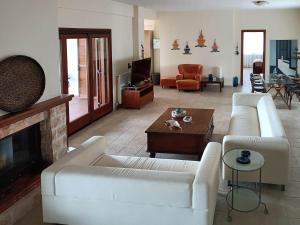 un soggiorno con divani bianchi e camino di Villa Totti a Ierissós