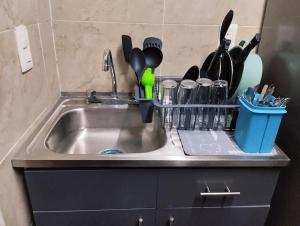 um lavatório de cozinha com uma prateleira de utensílios em Departamento Cerca del Aeropuerto/ Buena Ubicación em Cidade do México