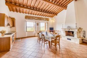 una cucina e una sala da pranzo con tavolo e camino di Santarcangelo Apartments - Happy Rentals ad Asciano