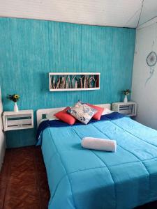 Un dormitorio azul con una gran cama azul con almohadas rojas en Cabañas Trabun Melipeuco, en Melipeuco