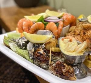 a plate of food with seafood and other foods at 1770 Lagoons Central Apartment Resort Official in Agnes Water