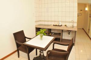 uma cozinha com uma mesa e cadeiras e um lavatório em Promenade Service Apartment em Kota Kinabalu