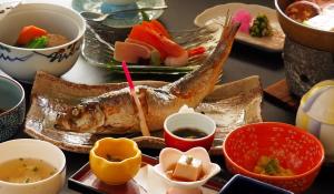a plate of food with a fish on a table at Central Hotel 中央ホテル in Chikuma