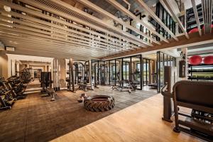 a gym with several treadmills and weights at Radisson Blu Hotel & Suites GRT Chennai in Chennai