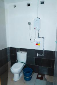 a bathroom with a toilet and a shower at Villa Uda @ SIBLINGS Cottage in Setiu