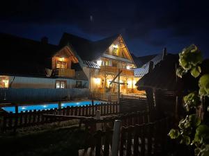a house with a swimming pool at night at W Dolinie Tylicza SPA & Wellness -gabinet masażu, saunarium-plac zabaw, rowery elektryczne, animacje dla dzieci in Krynica Zdrój