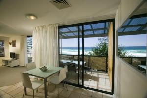 Sala de estar con mesa y vistas al océano en The Beach Retreat Coolum, en Coolum Beach