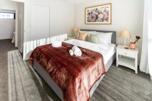 - une chambre avec un lit et 2 serviettes dans l'établissement Cozy 3 bedroom near Hagley Park w/Garage, à Christchurch