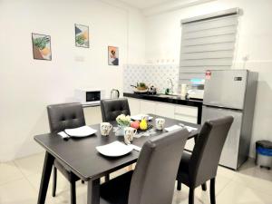 a kitchen with a table with chairs and a refrigerator at PROMO - Ipoh Casa Kayangan Meru, Pool View, Near Bus Station, Toll & Tambun, Free Wi-Fi, Free 3 Parking in Ipoh