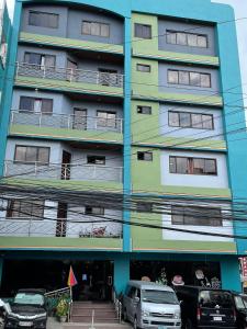 un edificio con auto parcheggiate di fronte di The Golden Pine Hotel a Baguio