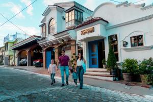a family walking down a street in front of a building at Hotel Boutique Casa José in Cobán