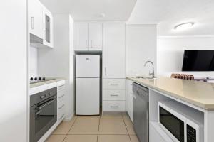 a kitchen with white appliances and a white refrigerator at Cairns Central Plaza Apartment Hotel in Cairns