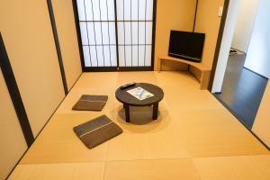 Pokój z dwoma matami, stołem i telewizorem w obiekcie Uji-Ichibanyado-Nigauri w mieście Ogurachō