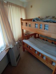 two bunk beds in a room with a window at Sapporo Guest House Nariya in Sapporo