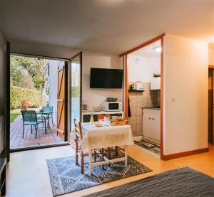 eine Küche und ein Wohnzimmer mit einem Tisch und einem Esszimmer in der Unterkunft Hôtel Studios Les Acacias in Saint-Paul-lès-Dax
