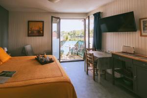 a bedroom with a bed and a desk with a table at Hôtel Studios Les Acacias in Saint-Paul-lès-Dax