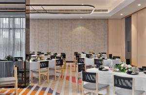 a dining room with white tables and chairs at Ginger Chandigarh, Zirakpur in Zirakpur