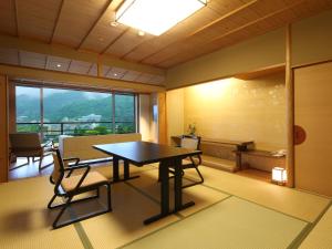 ein Esszimmer mit einem Tisch, Stühlen und einem Fenster in der Unterkunft Arima Grand Hotel in Kōbe