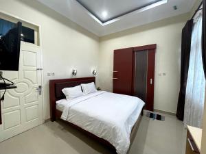 una camera con un letto e una televisione di OYO 92571 Zulyan Homestay Syariah a Bukittinggi