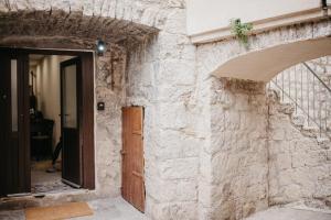 einen Eingang zu einem Steingebäude mit einer Holztür in der Unterkunft Studio apartment NI NA NA NA in Split
