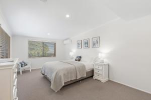 a white bedroom with a bed and a window at Montville Attic in Montville