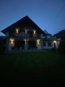 una casa iluminada por la noche con luces en Anna Pokoje Gościnne, en Krościenko nad Dunajcem