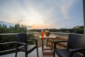 a table and chairs on a balcony with a bowl of fruit at heaven suite elafonisi in Elafonisi