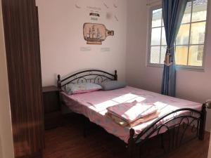 a bedroom with a bed in a room with a window at RPU Wen's Villa in Dauis