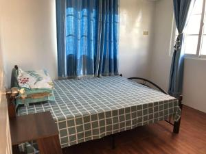 a small bedroom with a bed and a chair at RPU Wen's Villa in Dauis