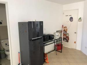 a kitchen with a black refrigerator in a room at RPU Wen's Villa in Dauis