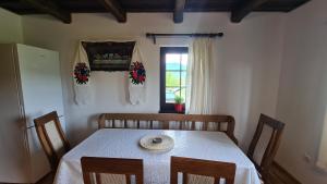 a dining room with a table and chairs and a window at Casa bunicilor din Oncești in Onceşti +24 photos
