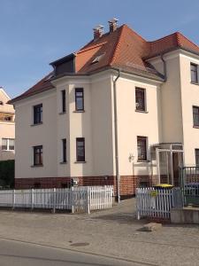 een groot wit huis met een rood dak bij Apartment Biesnitz in Görlitz