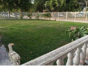 a white railing next to a yard with a grass field at Miami House in Miami