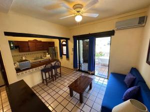 a living room with a blue couch and a kitchen at Vallarta Sun Suites in Puerto Vallarta