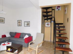 a living room with a couch and a spiral staircase at Villa Dima in Paleo Tsifliki