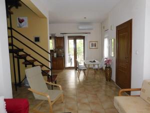 a living room with a staircase and a table and chairs at Villa Dima in Paleo Tsifliki