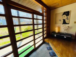 una stanza con una grande finestra in una casa di Nakao Villa (ナカオヴィラ） a Nozawa Onsen