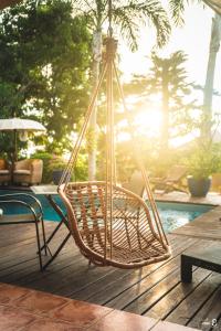 einem Klappstuhl auf einer Terrasse mit Pool in der Unterkunft La Villa Zen in Saint-Paul