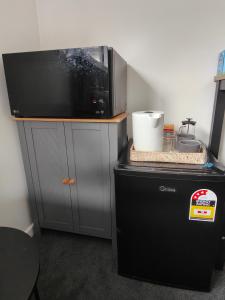 een magnetron bovenop een aanrecht naast een koelkast bij Quality Stay Private Guest Room in Auckland in Auckland