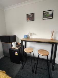 een bureau en 2 krukken in een kamer bij Quality Stay Private Guest Room in Auckland in Auckland