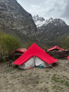 une tente rouge et blanche en face d'une montagne dans l'établissement Bored Ape Jispa - Camp Site, à Jispa