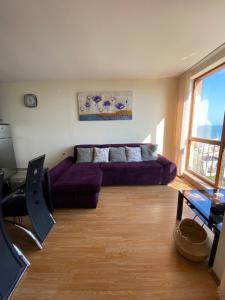 a living room with a purple couch and a table at Sea view apartment in Sveti Vlas in Elenite