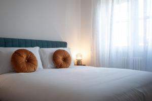 里米尼的住宿－[150 mt dal mare] FillYourHomeWithLove Apartment，一张带两个棕色枕头的白色床和窗户